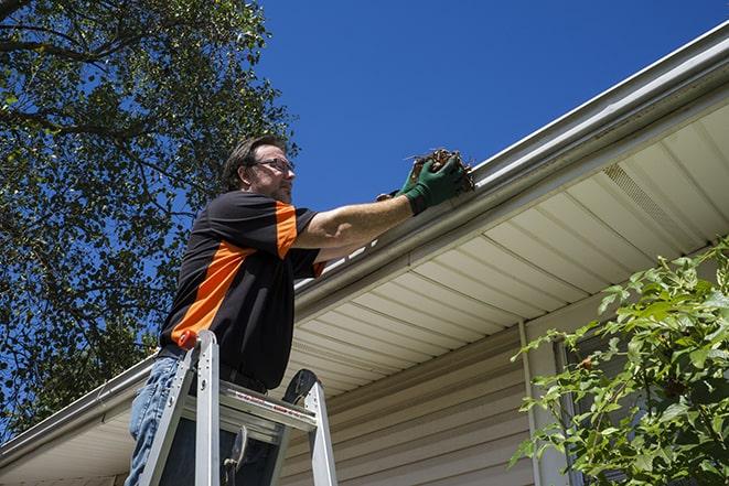 a person replacing a worn-out gutter on a building in Bloomingdale